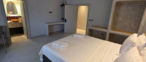 Une chambre à coucher avec un lit, un bureau, une chaise et un miroir.