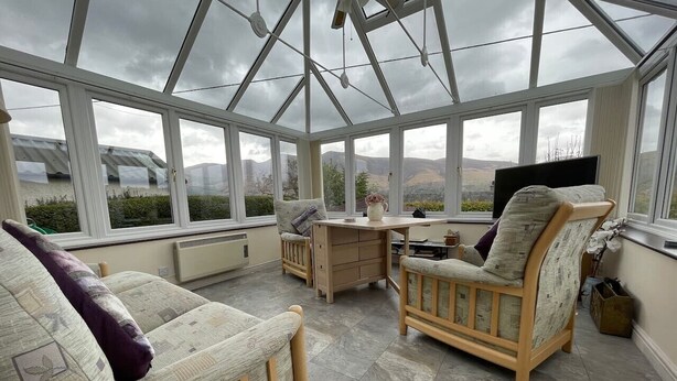 A conservatory with a glass ceiling, wooden furniture, and a view of the outdoors. - PANORAMIC views in the heart of the Lakes, Keswick (Portinscale)