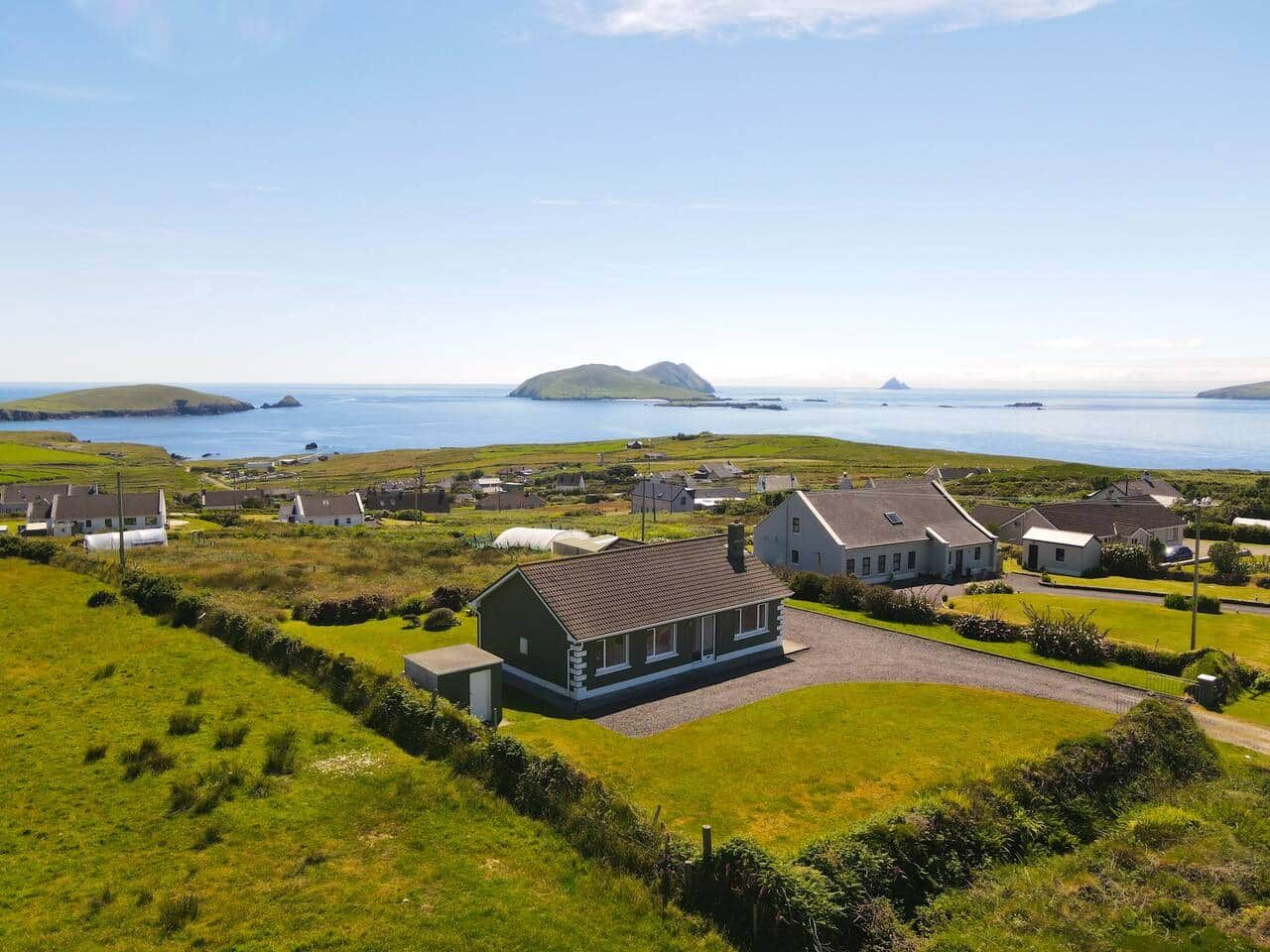 En kustby med hus, en gräsyta och utsikt över havet.