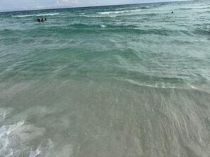 A beach with clear water and waves, and people swimming. - Coastal Luxury Villa: Private Pool, TV Patio (Mexico Beach)