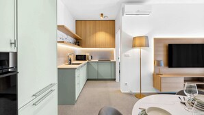 Una cucina moderna con zona pranzo, una TV a schermo piatto e una lampada da terra.