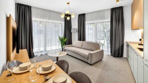 Ein modernes Hotelzimmer mit Essbereich, Sofa und Küchenzeile.