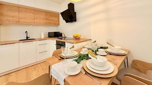 Een moderne keuken met houten kastjes, een eettafel voor vier personen en een bijzondere ronde lamp.