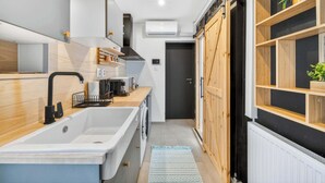 Eine moderne Küche mit integriertem Spülbecken, einer Kaffeemaschine und einer Holz Arbeitsplatte.