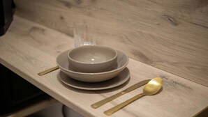 A wooden table with a bowl, a glass, and a spoon. - Elegant Studio in Historical Centrum | AC & Netflix (Košice I)