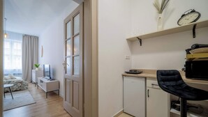 A compact living space with a kitchenette, a dining area, and a bedroom with a bed and a window. - Elegant Studio in Historical Centrum | AC & Netflix (Košice I)