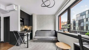 En kompakt bolig med tekøkken, en sovesofa og et spiseområde.