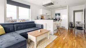 Un appartement moderne comprenant un espace de vie, une cuisine et un coin repas.