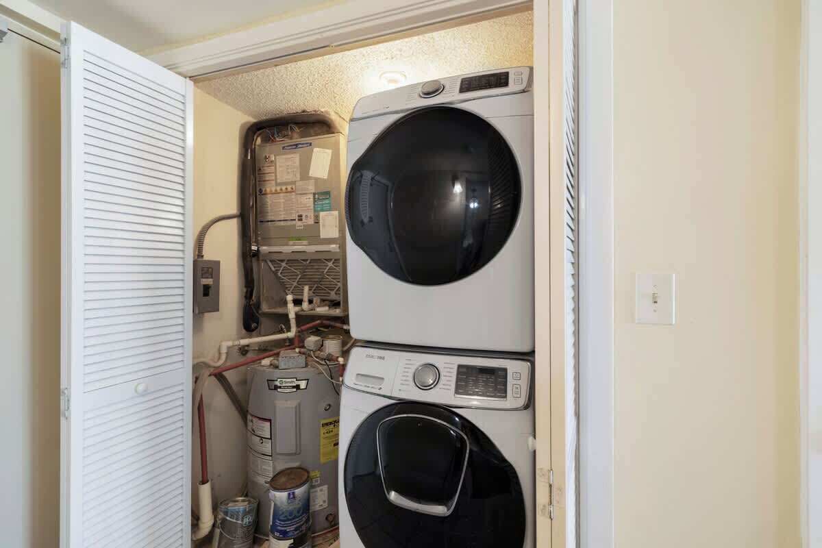 Een wasserette met gestapelde wasmachines en drogers, een boiler en een gasmeter.