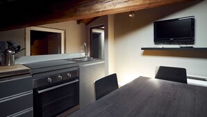 Eine moderne Küche mit Einbauofen, Spüle und Essbereich inklusive Tisch und Stühlen.