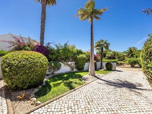 A paved pathway, palm trees, and well-maintained hedges in a garden setting. - Casa Carpe Diem - Amazing villa in Luz (Luz)