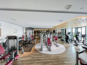 A gym with cardio machines, weight machines, and free weights. - Amazing 1BR, 10 mins to Burj Khalifa (Dubai)