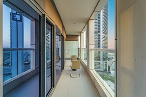 A modern corridor with large windows, a glass railing, and a view of high-rise buildings. - Amazing 1BR, 10 mins to Burj Khalifa (Dubai)