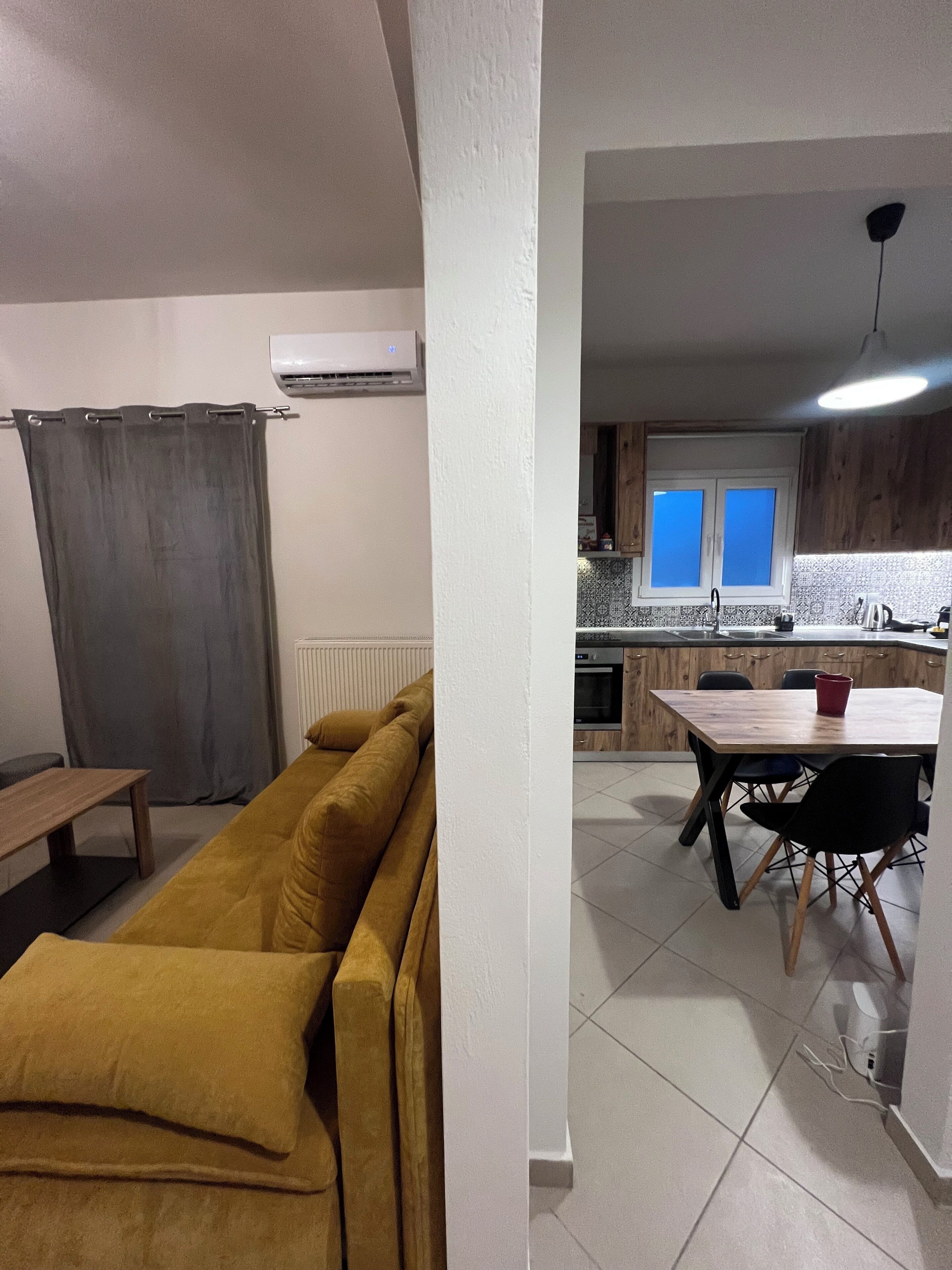 Una sala de estar con un sofá y un comedor con una mesa y sillas.