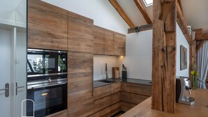 A modern kitchen with wooden cabinetry, stainless steel appliances, and a built-in oven.