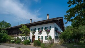 A traditional chalet with a sloped roof, wooden exterior, and green shutters.