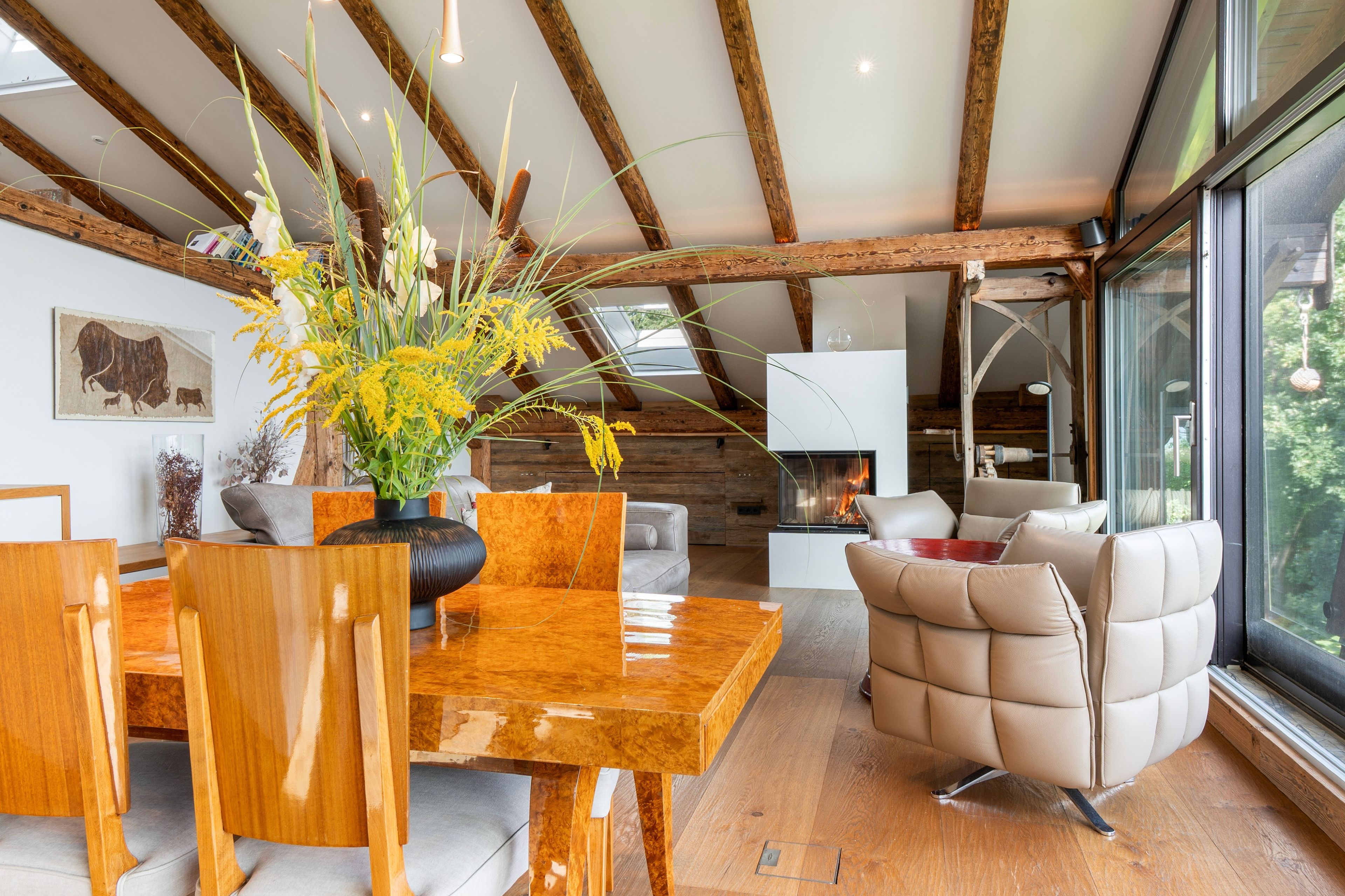 Ein modernes Interieur mit einem Holzesstisch, einer Couch und einem Kamin.