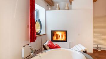 Ein modernes Badezimmer mit einer freistehenden Badewanne, einem Kamin und einem großen Spiegel.