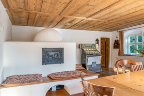 Ein Essbereich mit Holztisch und Stühlen, einem dekorativen Wandelement und einem Vintage-Jukebox.