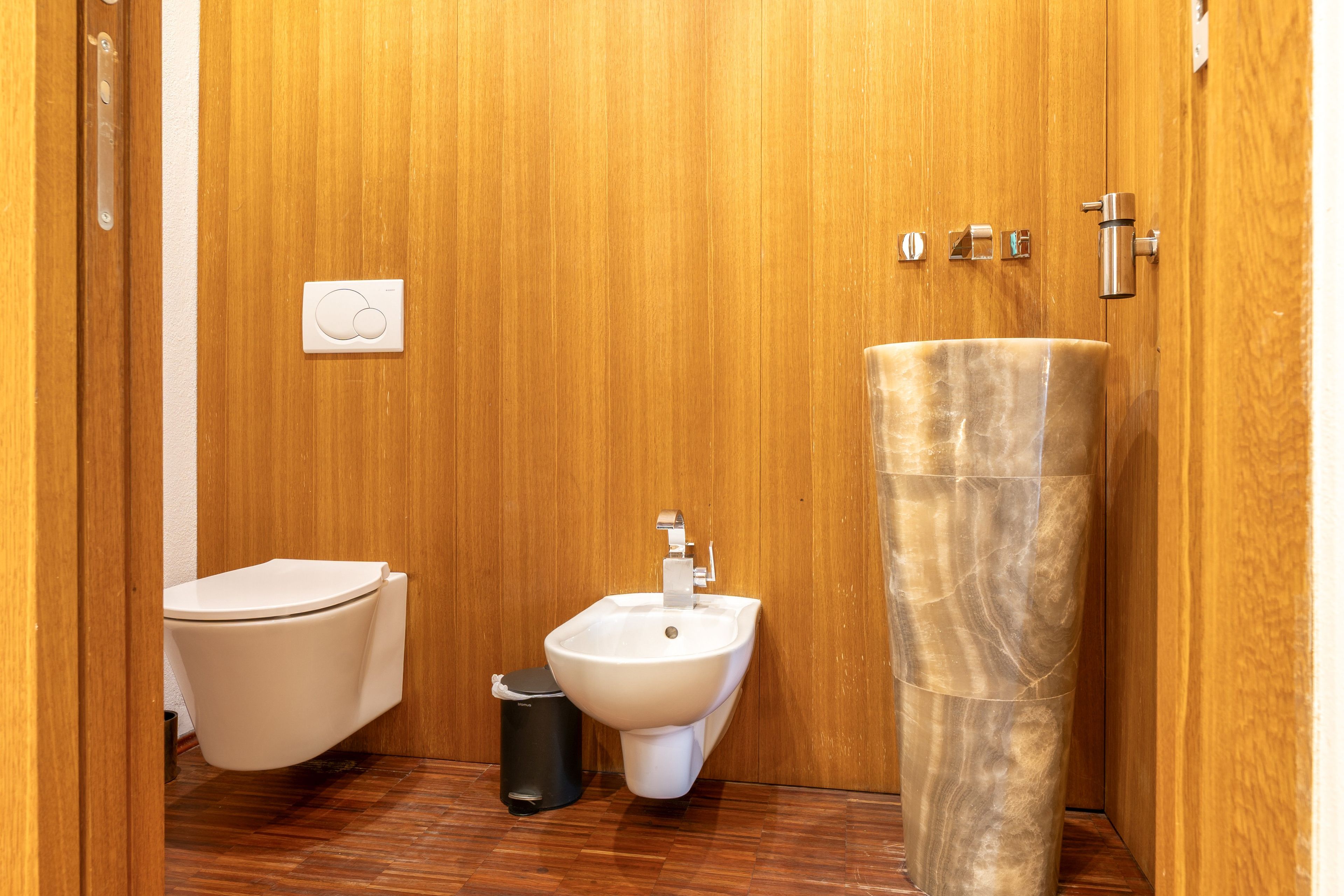 Ein kleines Badezimmer mit Toilette, Bidet und einem Marmorwaschbecken.