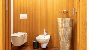 Ein kleines Badezimmer mit Toilette, Bidet und einem Marmorwaschbecken.