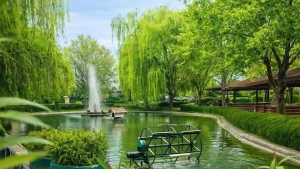 A serene park with a pond, a gazebo, and a fountain. - Hotel Bellevue (Ilinden)