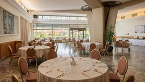 A spacious banquet hall with round tables set for dining, large windows, and a high ceiling. - Hotel Bellevue (Ilinden)