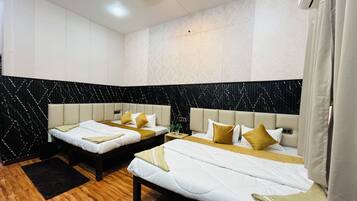 Habitación de hotel con dos camas, una pared estampada en blanco y negro y suelo de madera.