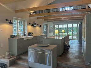 A modern kitchen with a central island, built-in appliances, and a view to the outdoors. - Luxury holiday home with indoor pool in Hornbæk (Hornbæk)