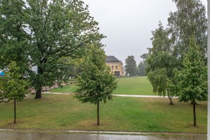 Ein Park mit einem Gebäude im Hintergrund, Bäumen und einem gepflasterten Weg.