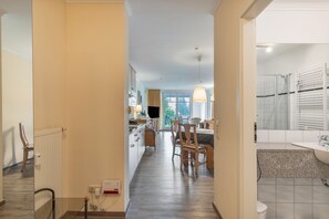 Ein Hotelkorridor mit Essbereich, Küche und Bad.