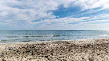 Een strand met een zandstrand en de oceaan op de achtergrond.