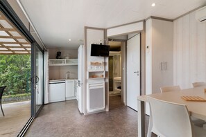 Eine moderne Küche mit Einbauofen, Kaffeemaschine und einem an der Wand befestigten Fernseher.
