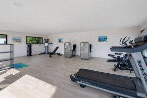 A gym with treadmills, a weight bench, and a rowing machine. - Chalet 'Notre Rêve en Bord de Mer' with shared pool, Wi-Fi and air conditioning (Santa-Maria-Poggio)
