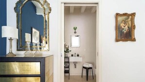 A room with a mirror, a dresser, a framed picture, a sink, and a stool. - The Muse... (Venice)