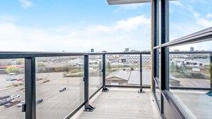 A balcony with a view of a parking lot and buildings. - Modern High Rise Condo w Private Patio Downtown (Kitchener)