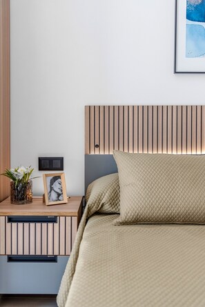 A bedroom with a bed, bedside table, and a wall-mounted light fixture. - Oasis Laguna Resort Pool & View Premium III (Guardamar)