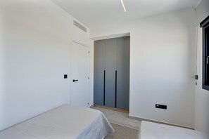 A bedroom with a bed, a wardrobe, and a door. - Oasis Laguna Resort Pool & View Premium III (Guardamar)