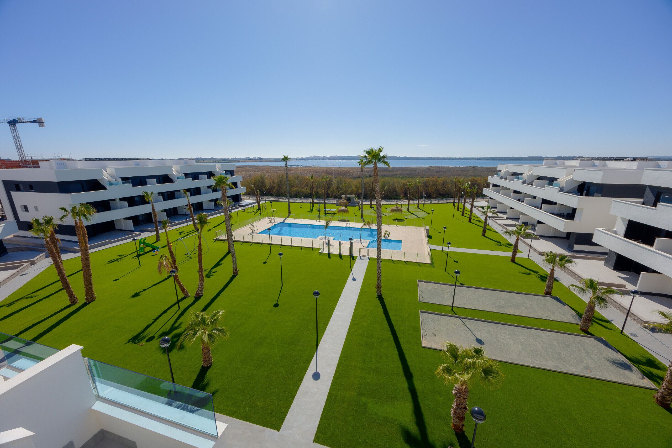 Ein modernes Hotel mit mehreren Etagen, einem zentral gelegenen Schwimmbad und Meerblick.