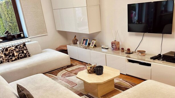 A modern living room with a sofa, coffee table, TV, and cabinets. - Room-private Room With Shared Bathroom (Clavier)