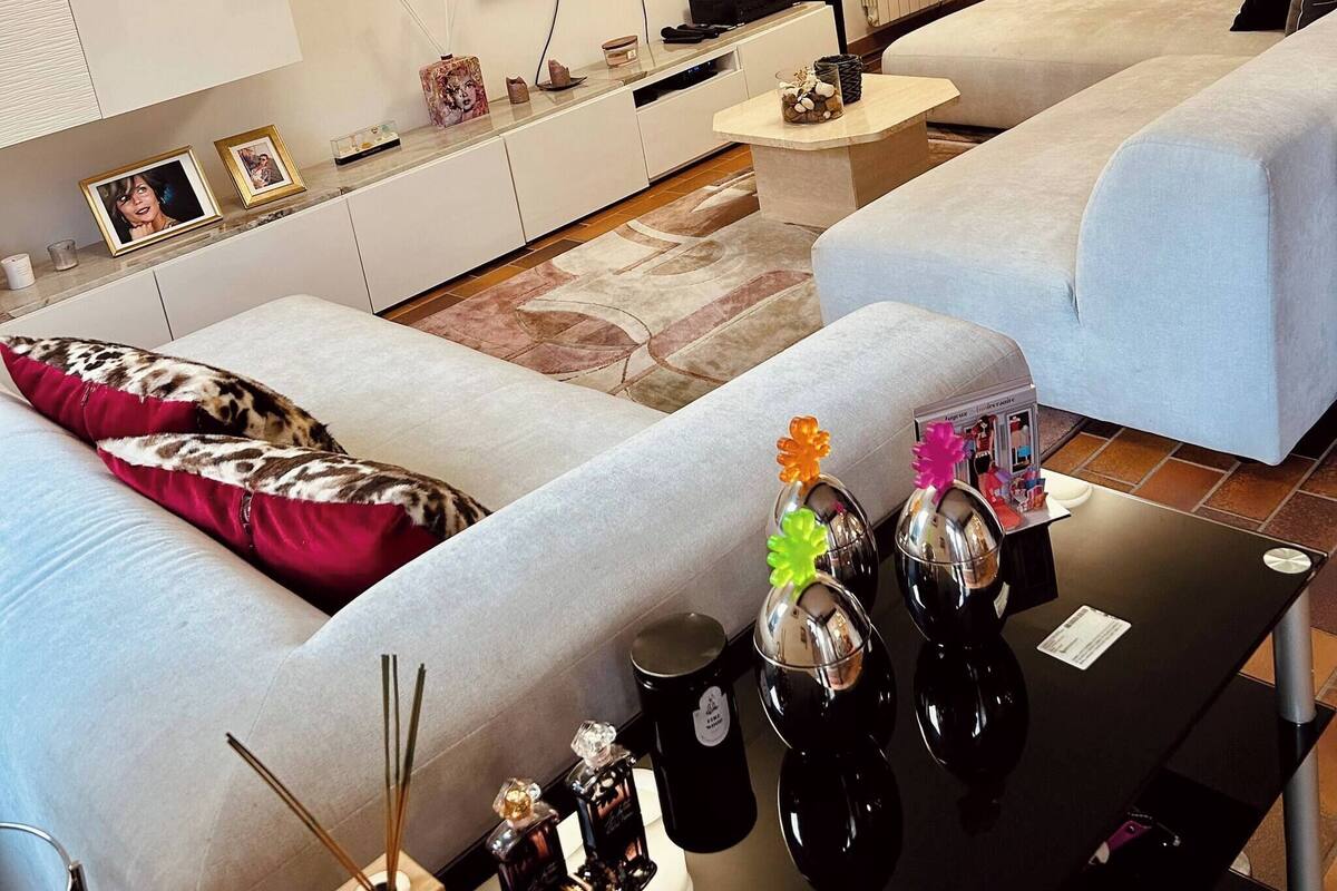 A modern living room with two sofas, a flat-screen TV, a coffee table, and a small side table.