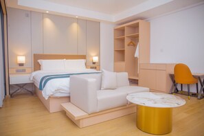 A modern hotel room with a bed, a sofa, a small table, a desk, and a chair. - LEAF HOTEL (Dar es Salaam)