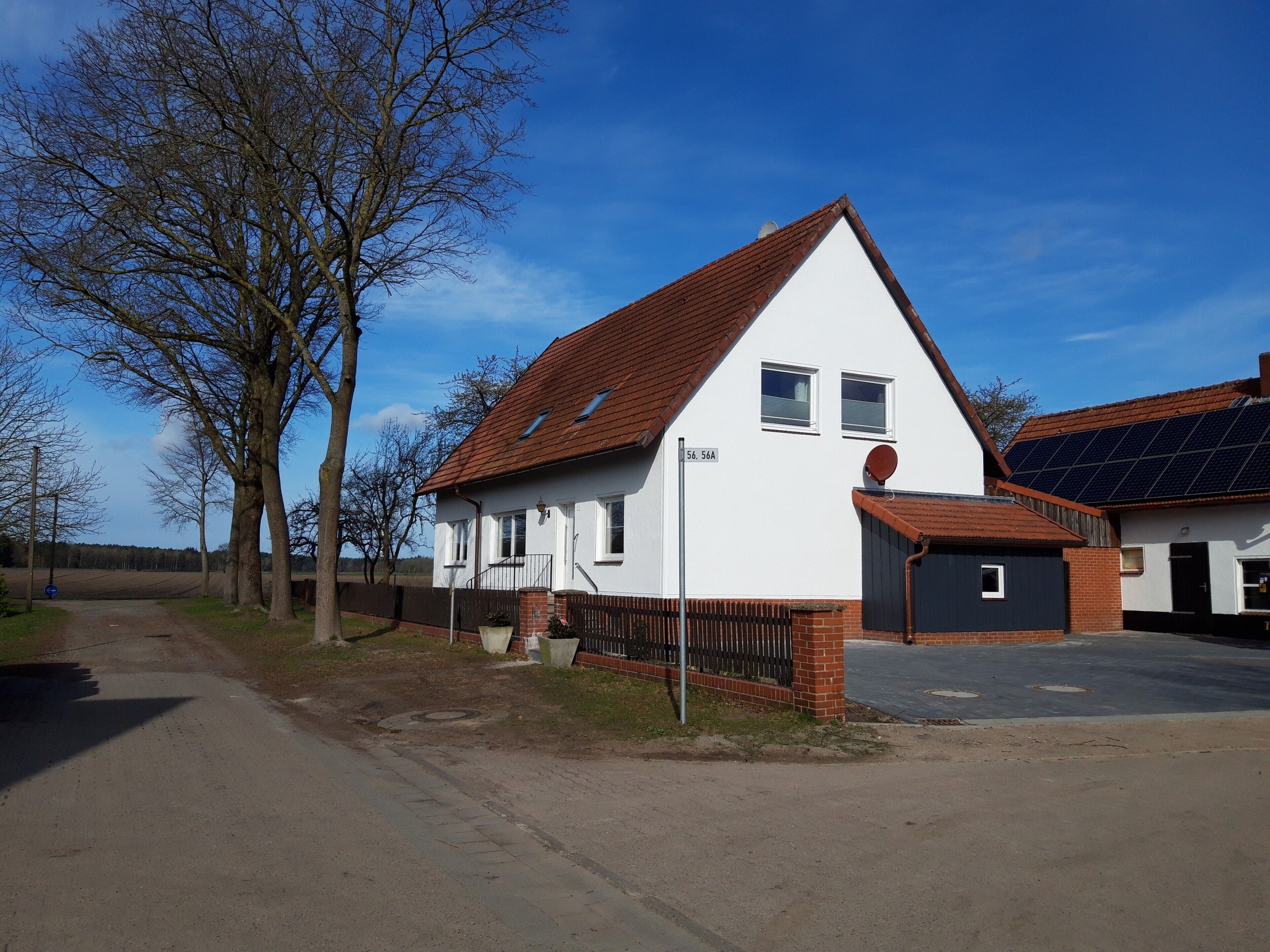 Ein Wohnhaus mit geneigtem Dach, einer Satellitenschüssel und Solaranlage.