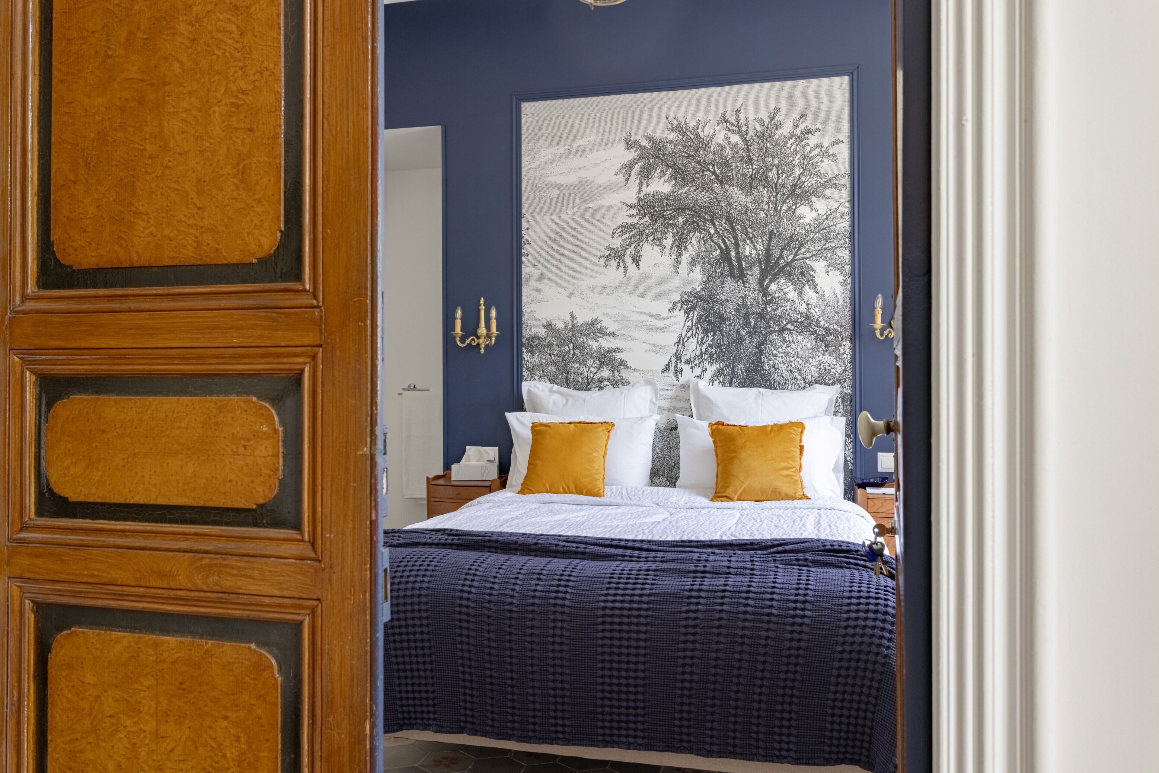 Ein Schlafzimmer mit einem Bett, einem großen gerahmten Bild und einem Nachttisch.