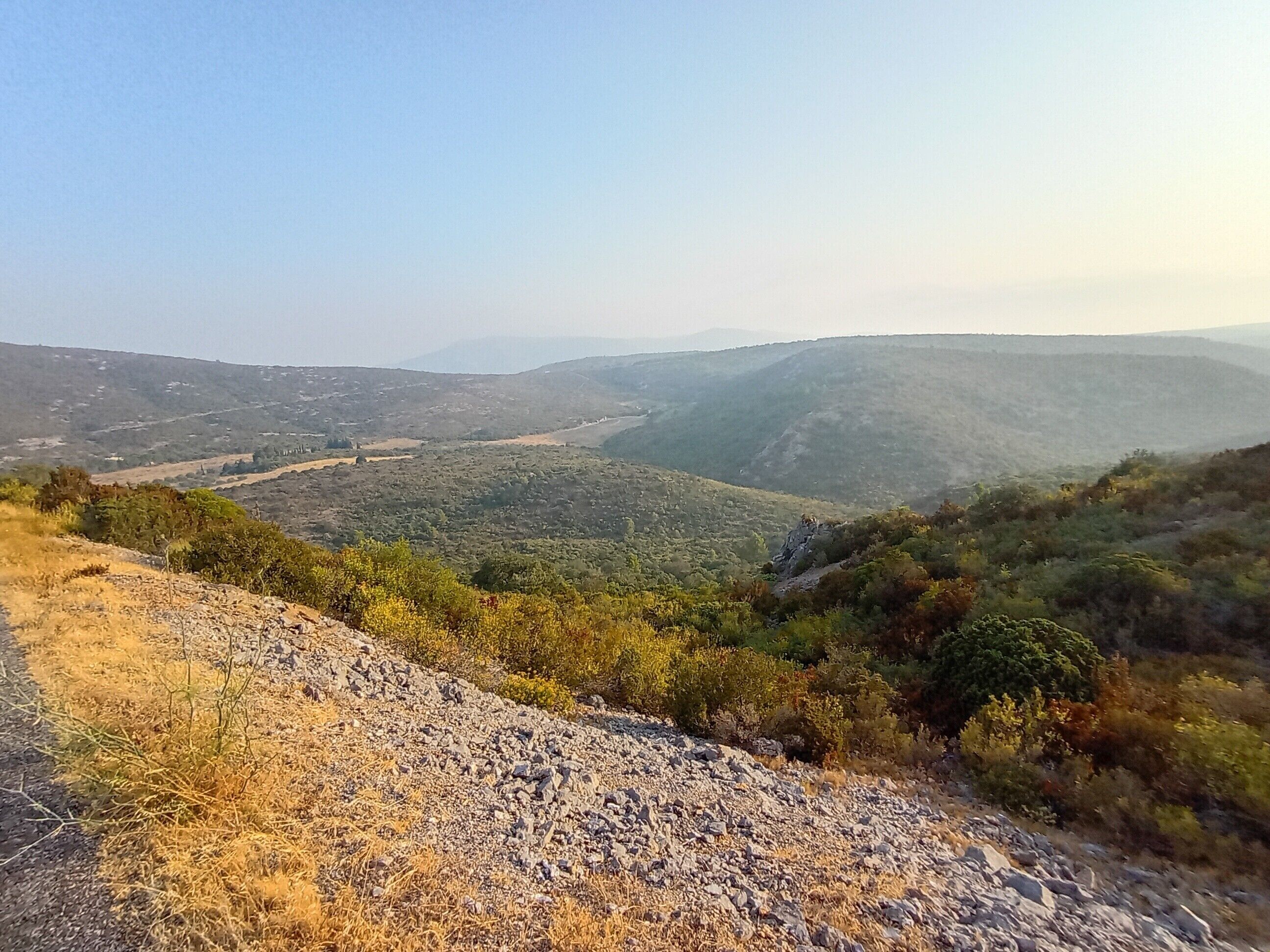 A mountainous landscape with a dirt path leading through a valley.