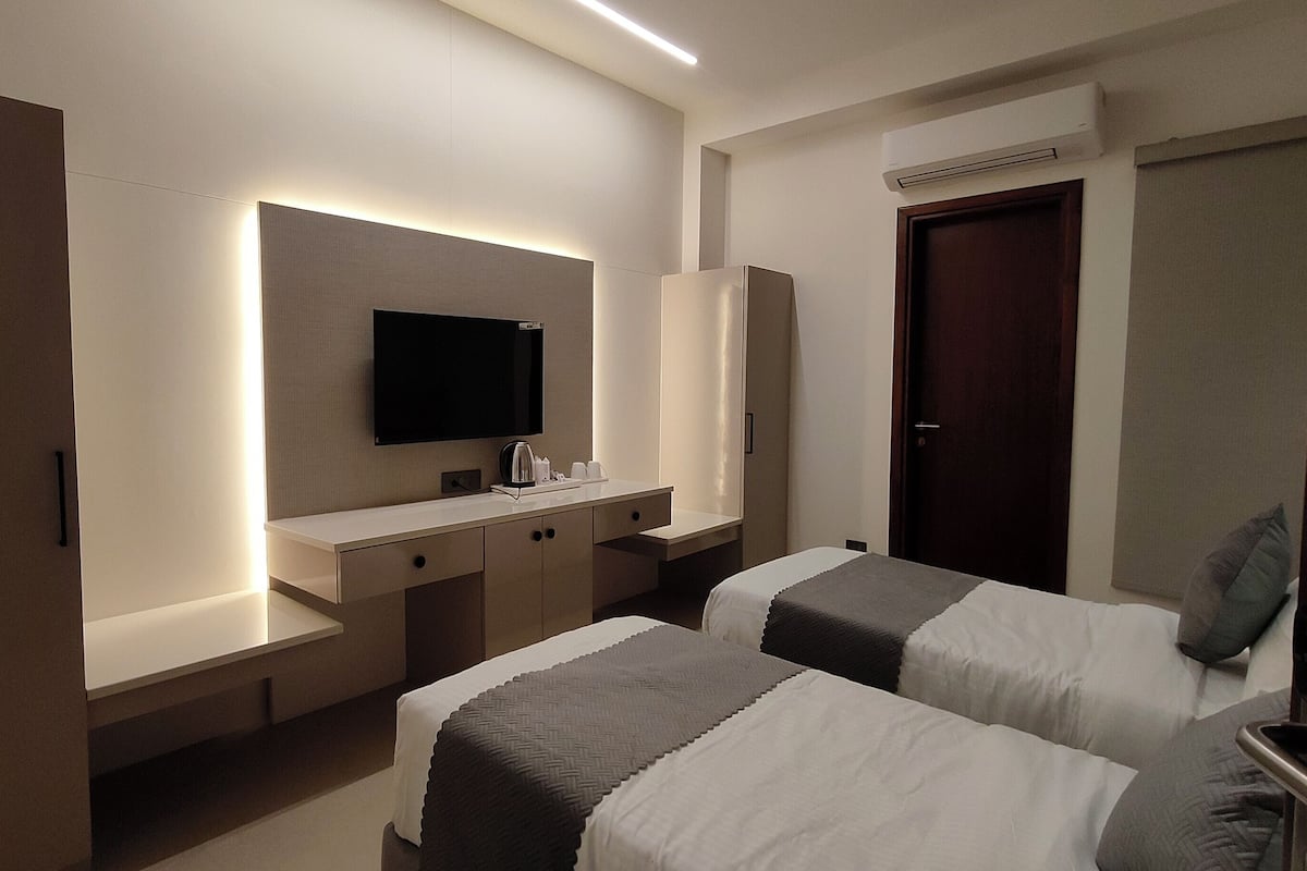 Habitación ejecutiva con 2 camas individuales | Escritorio, espacio para trabajar con laptop y cortinas blackout
