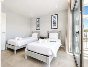 Een hotelkamer met twee bedden, een klein tafeltje en een raam met uitzicht.