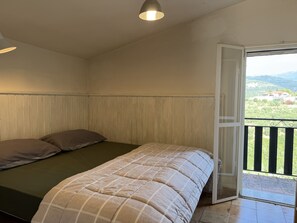 A bedroom with a bed, a window, and a view of a landscape. - Retreat Zerbo Viesci (Chiusavecchia)