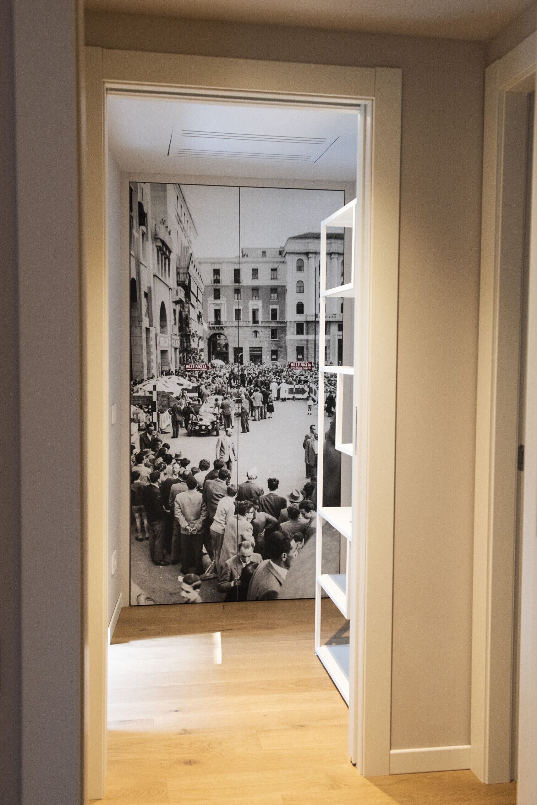 A hallway with a black and white photograph of a crowded street scene.
