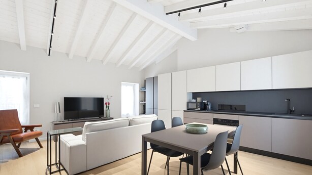 A modern living space with a dining area, kitchen, and seating. - 1000 Miglia Apartment BSC (Brescia)